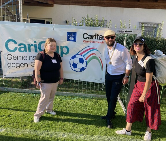 Stefan Pimmingstorfer mit Celina und Barbara vor dem CariCup Plakat 