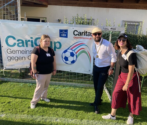 Stefan Pimmingstorfer mit Celina und Barbara vor dem CariCup Plakat 