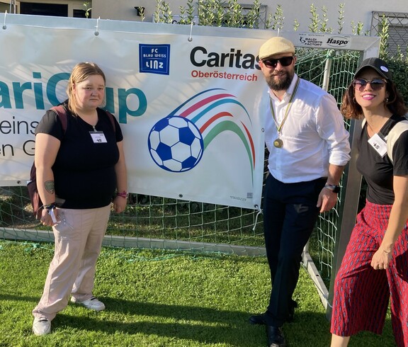 Stefan Pimmingstorfer mit Celina und Barbara vor dem CariCup Plakat 